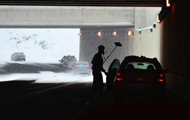 A driver returns to his car after stooping beneath Hagerstown Regional Airport runway to clear his windows Sunday, Dec. 8, 2013.   A powerful storm that crept across the country dumped a mix of snow, freezing rain and sleet on the Mid-Atlantic region and headed northeast Sunday, turning NFL playing fields in Pennsylvania into winter wonderlands, threatening as much as a foot of snow in Delaware and New Jersey and raising concerns about a messy morning commute. (AP Photo/The Herald-Mail, Kevin G. Gilbert)
